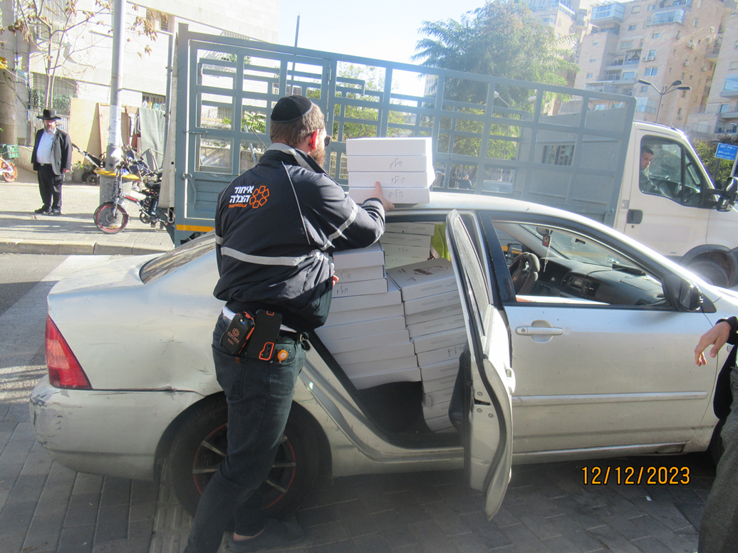 A volunteer loading boxes of food into a car