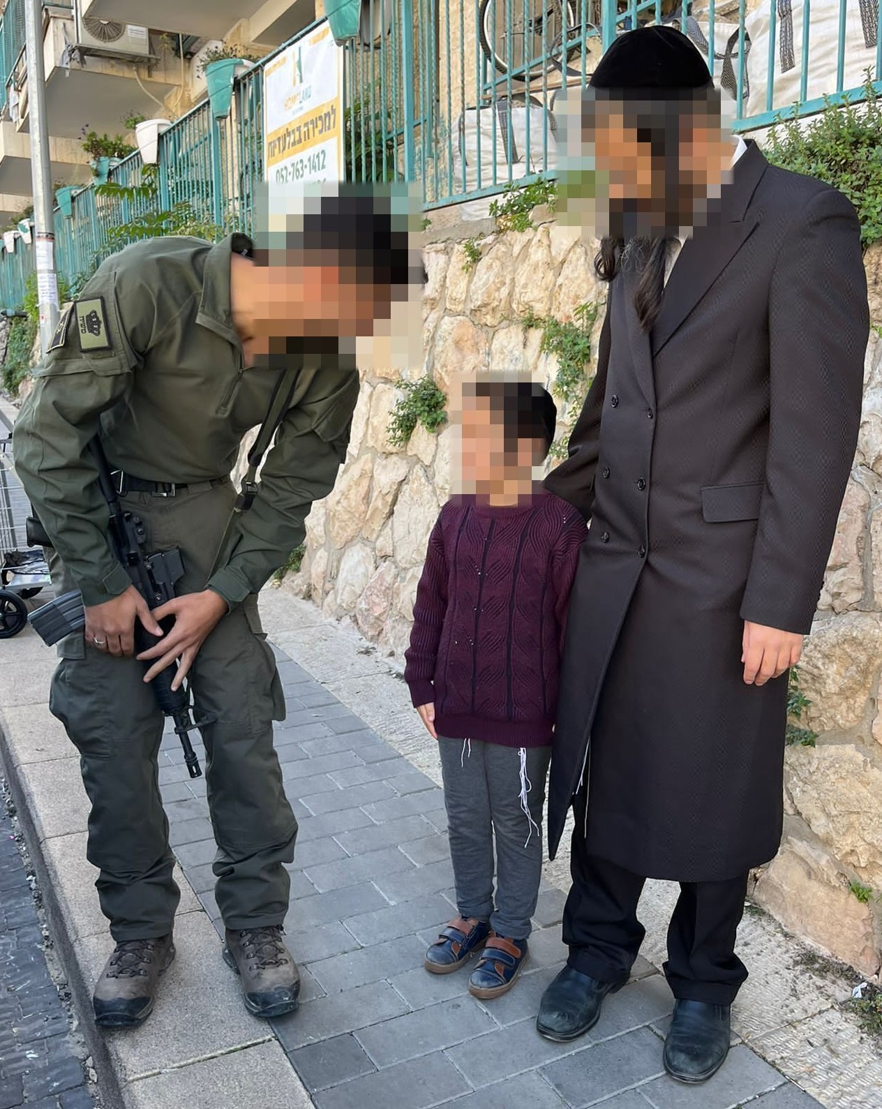 A soldier meeting members of a family, with faces obscured for privacy